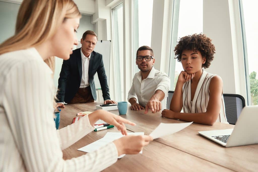 Group of young business people reviewing documents around an office table