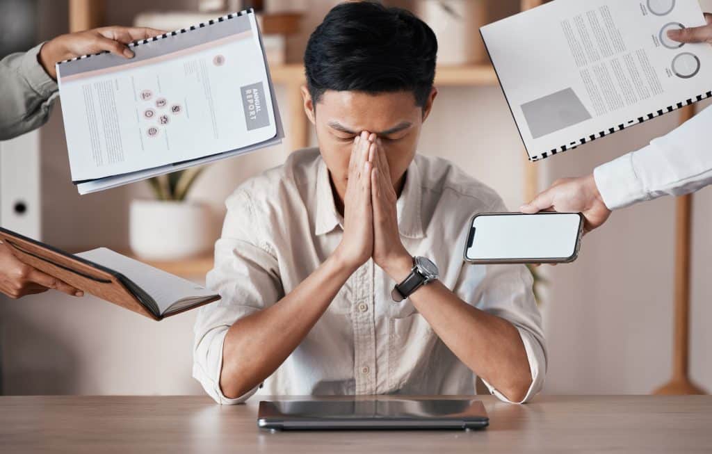 Stressed, overworked businessman looking frustrated at his office desk